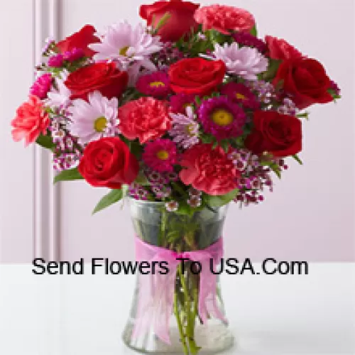 Rote Rosen, rote Nelken und andere verschiedene Blumen, wunderschön in einer Glasvase arrangiert