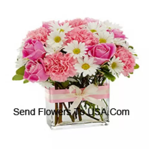 Rose rosa, garofani rosa e fiori bianchi assortiti stagionali disposti splendidamente in un vaso di vetro