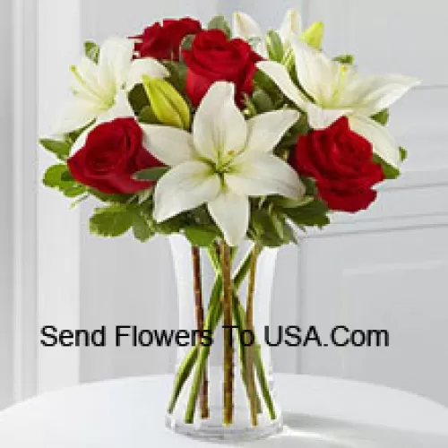 Rote Rosen und weiße Lilien mit einigen saisonalen Füllstoffen in einer Glasvase