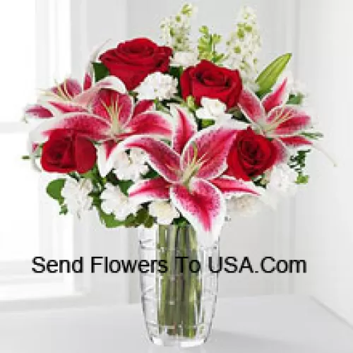 Rose rosse, gigli rosa con fiori bianchi assortiti in un vaso di vetro